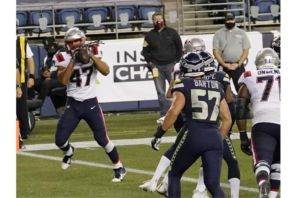 Jakob Johnson (l) von den New England Patriots fängt einen Touchdown. Foto: Elaine Thompson/AP/dpa