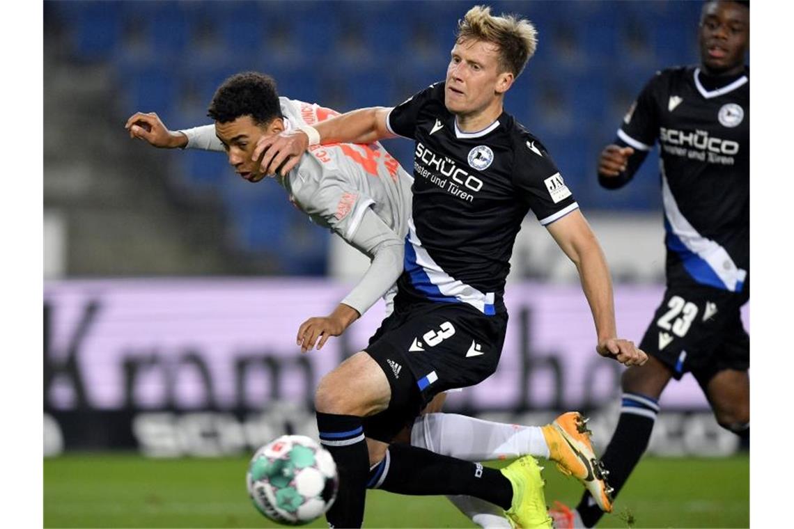Bundesliga: Das war der Samstag, das bringt der Sonntag Jamal Musiala (l) von Bayern in Aktion gegen Brian Behrendt (M) von Bielefeld. Foto: Martin Meissner/AP-Pool/dpa