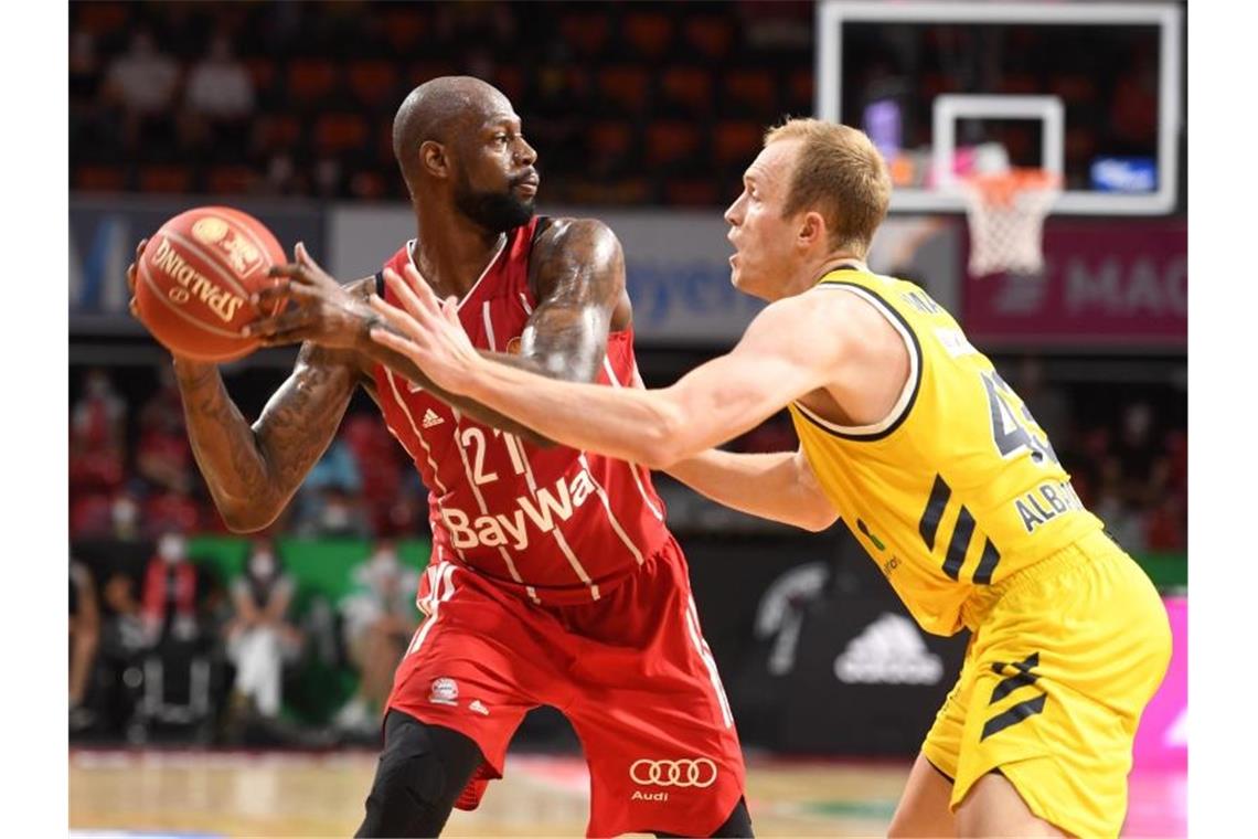 James Gist von Bayern München und Luke Sikma von Berlin kämpfen um den Ball. Foto: Tobias Hase/dpa