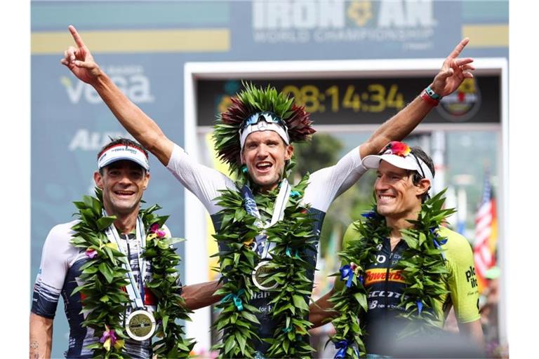 Jan Frodeno (M) feiert auf Hawaii beim letzten Ironman 2019 seinen Sieg. Foto: David Pintens/BELGA/dpa
