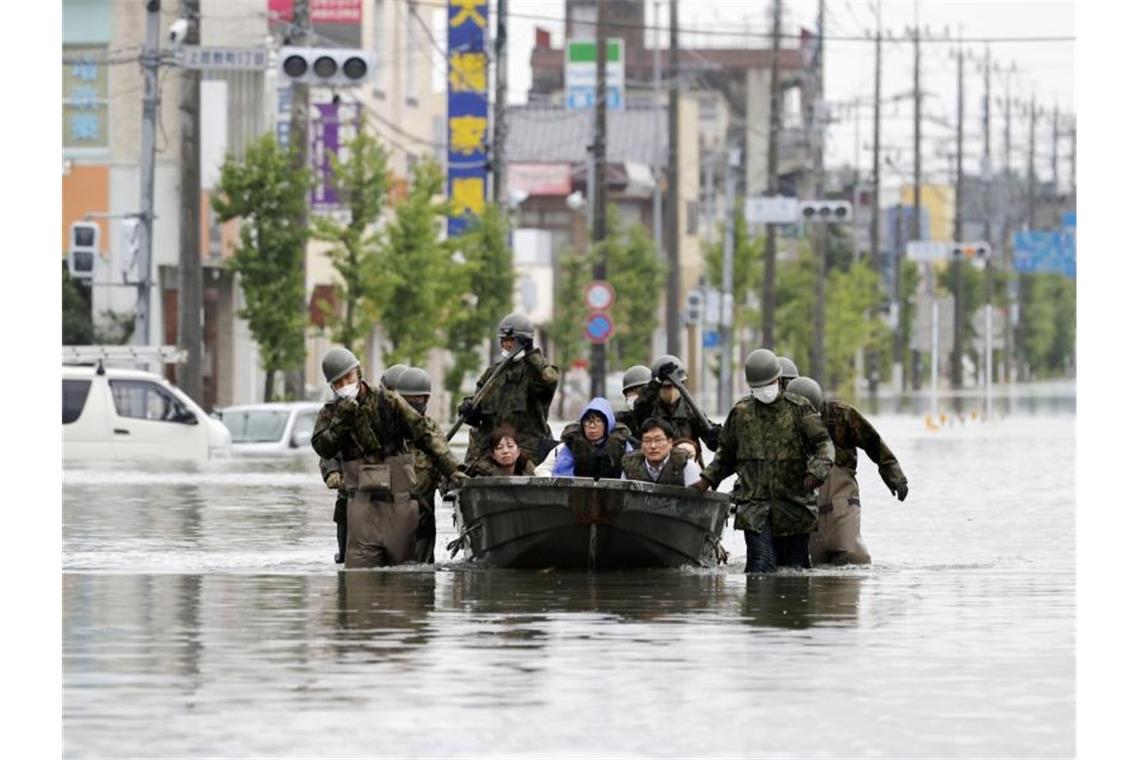 Japanische Soldaten beim Rettungseinsatz in den überschwemmten Straßen von Omuta. Foto: Juntaro Yokoyama/Kyodo News/AP/dpa