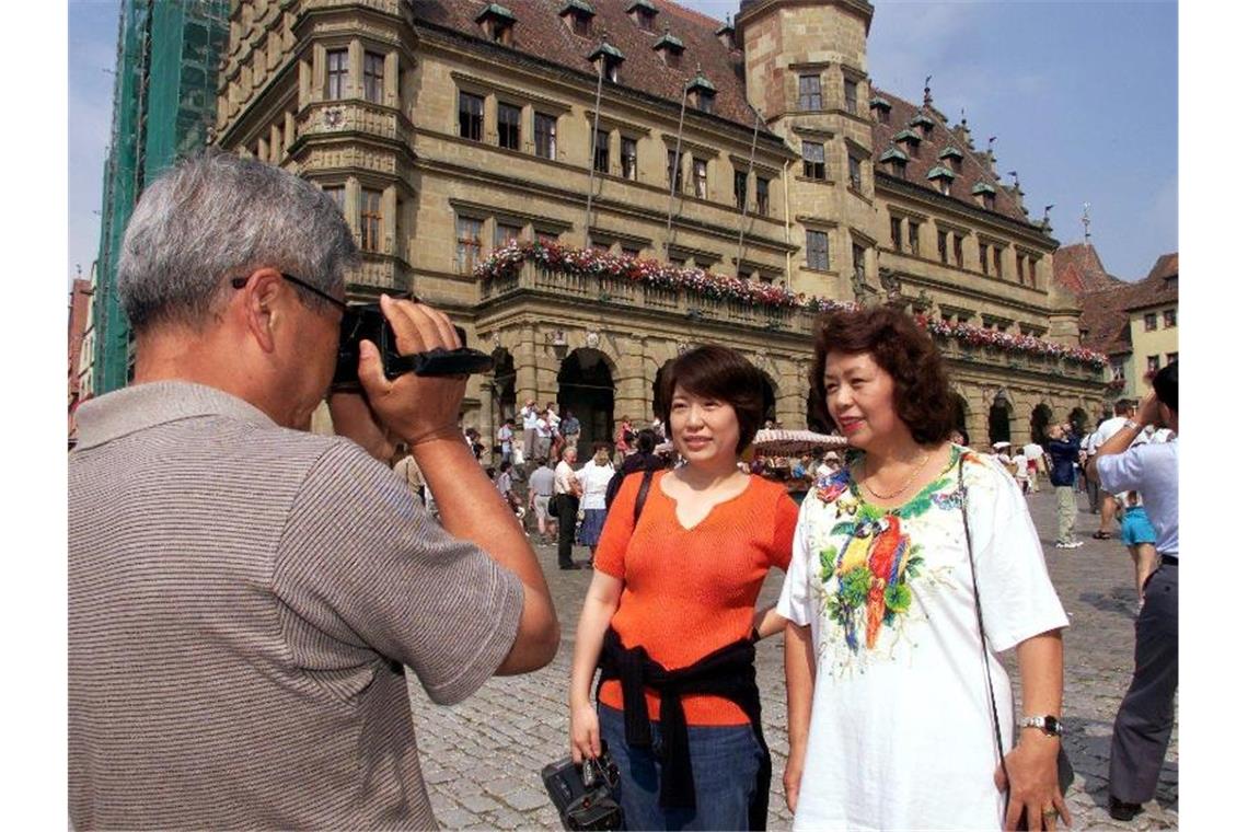 Japanische Touristen vor dem Renaissance-Rathaus in Rothenburg ob der Tauber. Foto: Stefan Kiefer