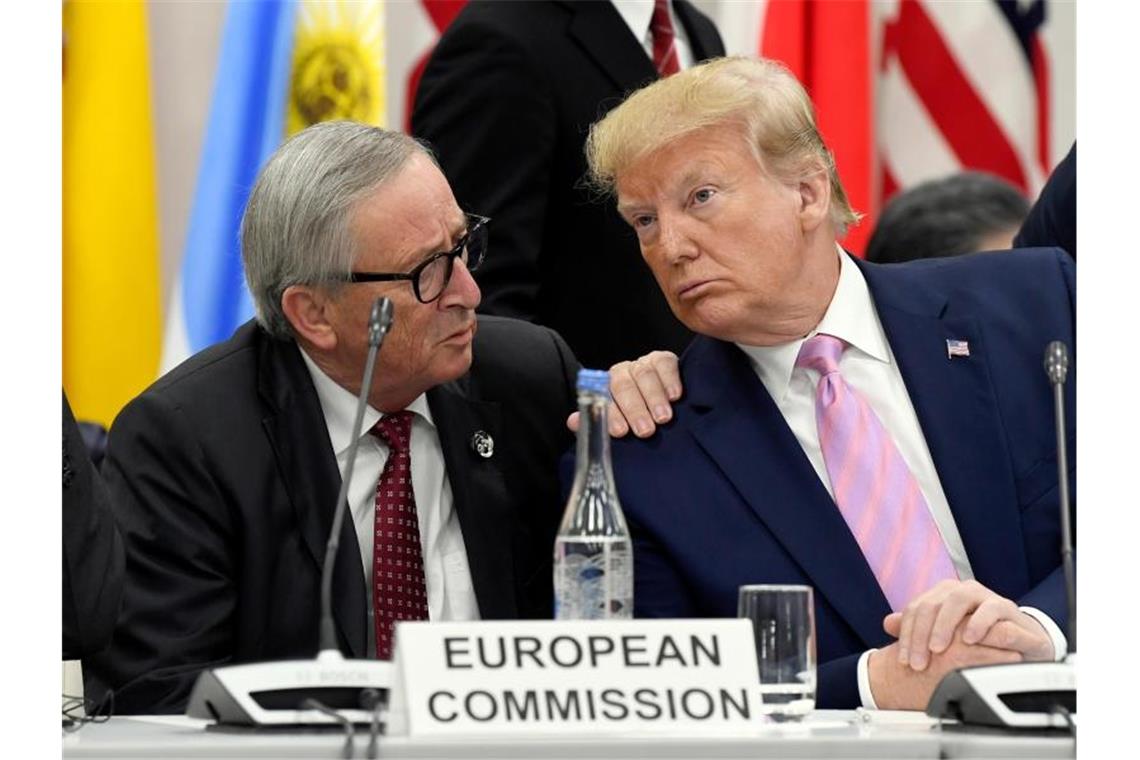 Jean-Claude Juncker (l.) beim vergangen G20-Gipfel in Osaka, Japan, im Gespräch. Der scheidende EU-Kommissionspräsident Juncker cglaubt nicht, dass US-Präsident Trump neue Autozölle erhebt. Foto: Susan Walsh/AP/dpa/Archiv