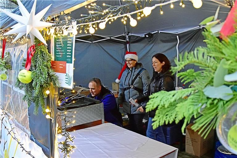 Jens Mayer kontrolliert den Gasanschluss am Stand des Tennisvereins. Stephanie Faber (Mitte) und Jennifer Reinert begleiten ihn auf seinem Rundgang. Foto: Tobias Sellmaier