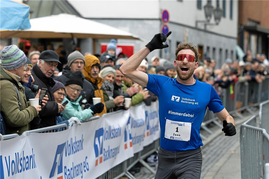 Jens Mergenthaler jubelt beim Zieleinlauf: Der 28-Jährige hat zum sechsten Mal den Backnanger Silvesterlauf gewonnen und dabei den Streckenrekord geknackt.  Foto: Alexander Becher