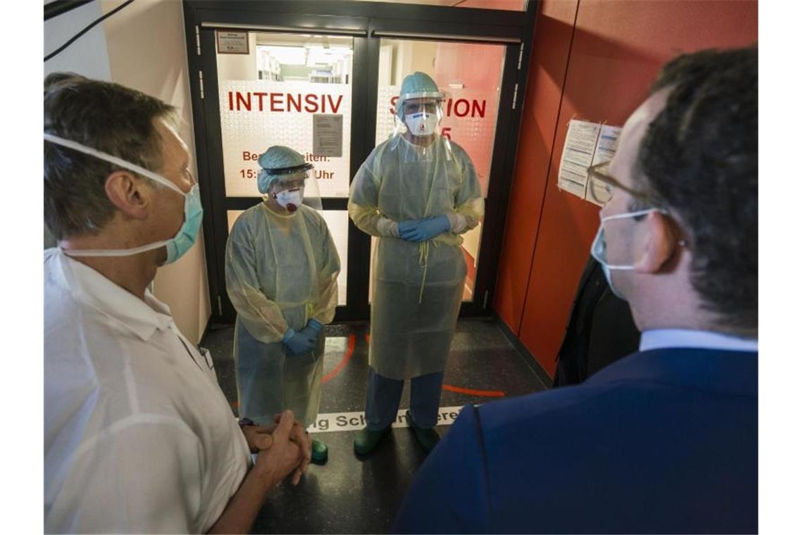 Jens Spahn (r) zu Besuch im Uniklinikum Gießen. Der Gesundheitsminister zeigt sich mit dem Verhalten der Bürger am Osterwochenende zufrieden. Foto: Frank Rumpenhorst/dpa Pool/dpa