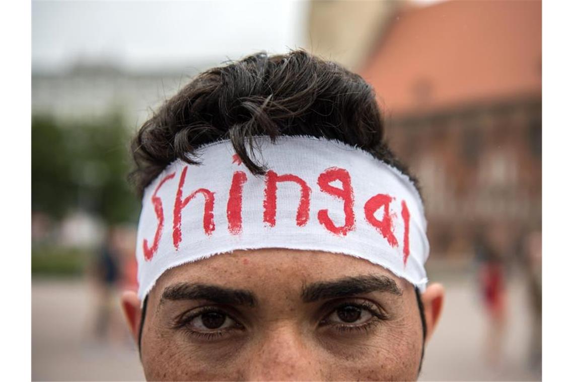 Jesidischer Flüchtling aus dem Irak mit Stirnband-Aufschrift „Shingal“, dem kurdischen Namen der Stadt Sindschar. Foto: Wolfram Kastl/Archiv