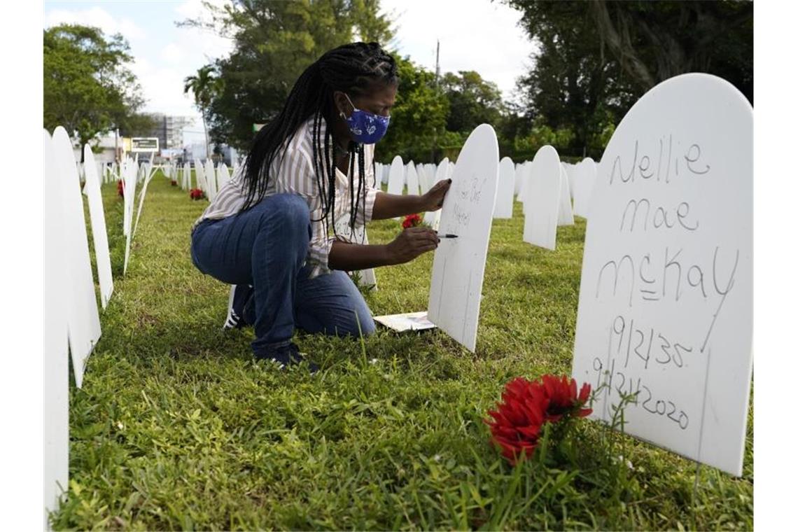 Joanna Moore schreibt einen Text auf einen Grabstein, der an ihren Cousin Wilton „Bud“ Mitchell erinnern soll, der am Coronavirus gestorben ist. Foto: Lynne Sladky/AP/dpa