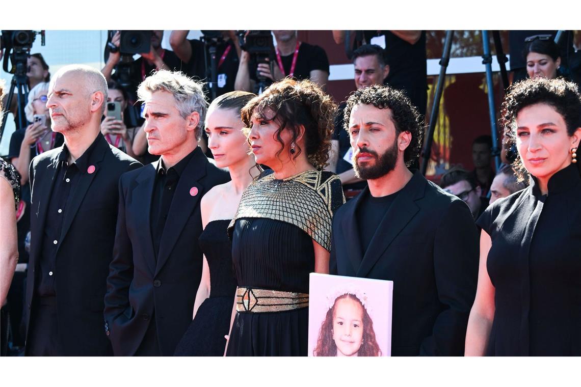 Joaquin Phoenix und Rooney Mara mit einem Teil des Filmteams und einem Foto von Hind Rajab auf dem roten Teppich.