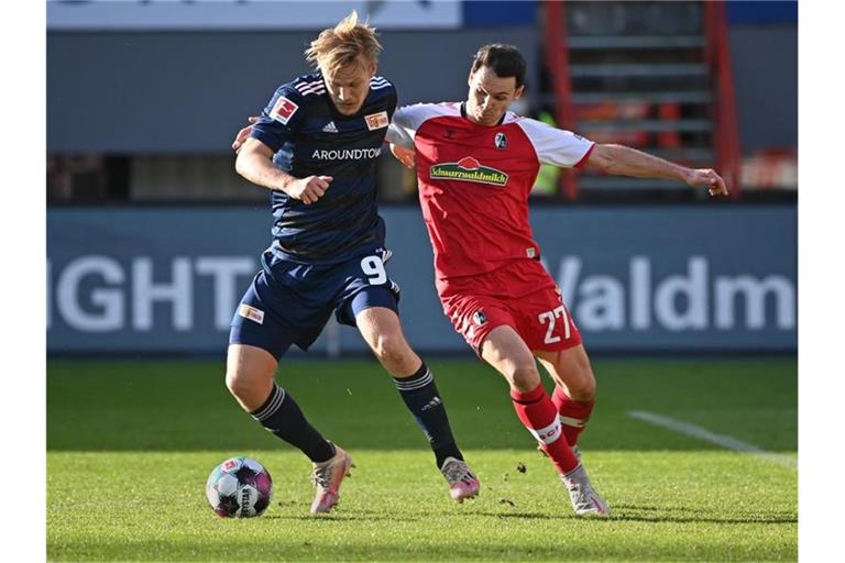 Joel Pohjanpalo von Berlin und Freiburgs Nicolas Höfler (l-r.) am Ball. Foto: Sebastian Gollnow/dpa