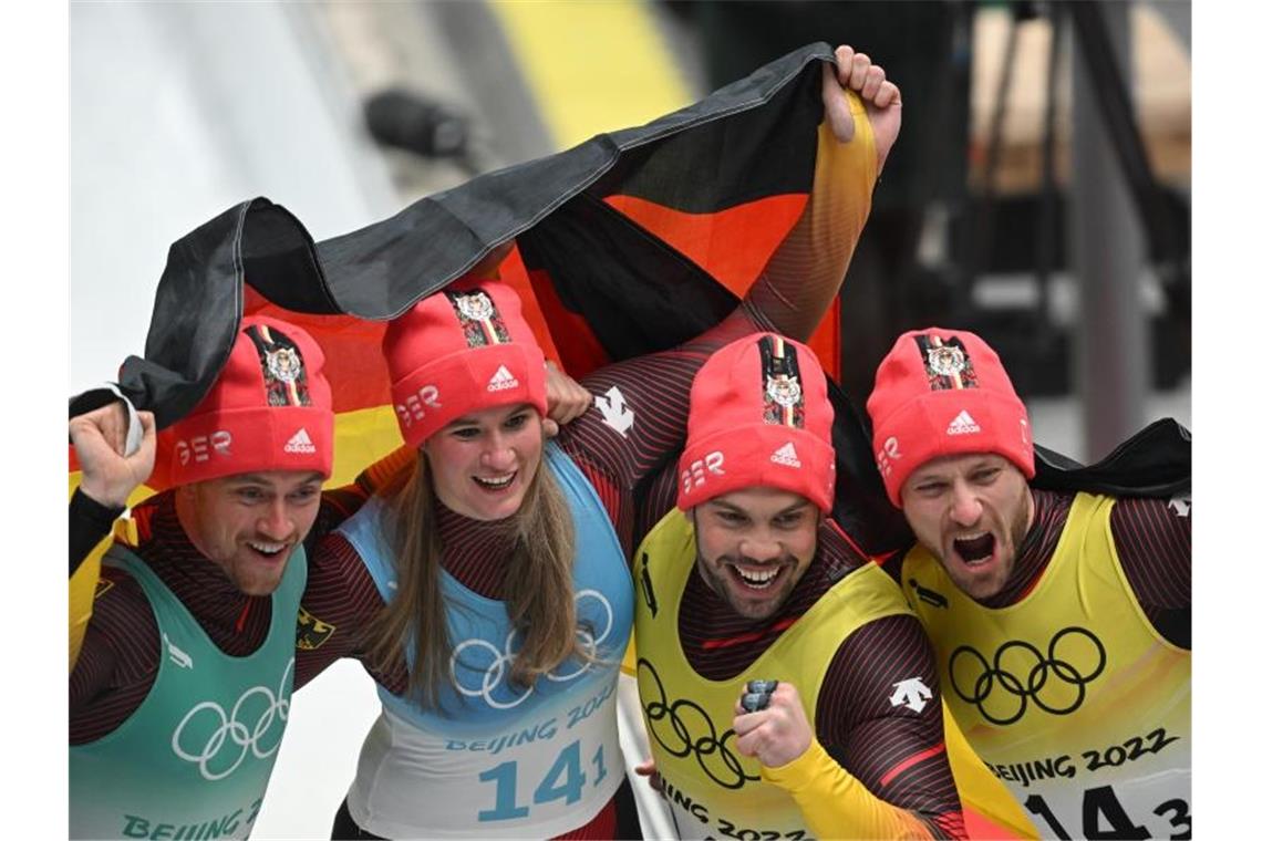 Johannes Ludwig, Natalie Geisenberger, Tobias Wendl und Tobias Arlt jubeln über Team-Gold. Foto: Robert Michael/dpa-Zentralbild/dpa