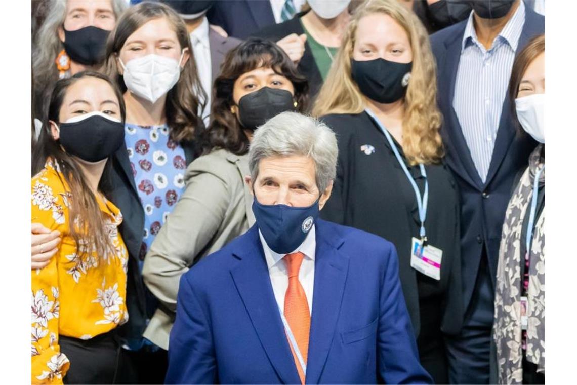 USA und China wollen Kooperation bei Klimaschutz ausbauen John Kerry (M), Sondergesandter des US-Präsidenten für das Klima, stellt sich bei der UN-Klimakonferenz COP26 in Glasgow bei einem Bildtermin zusammen. Foto: Christoph Soeder/dpa