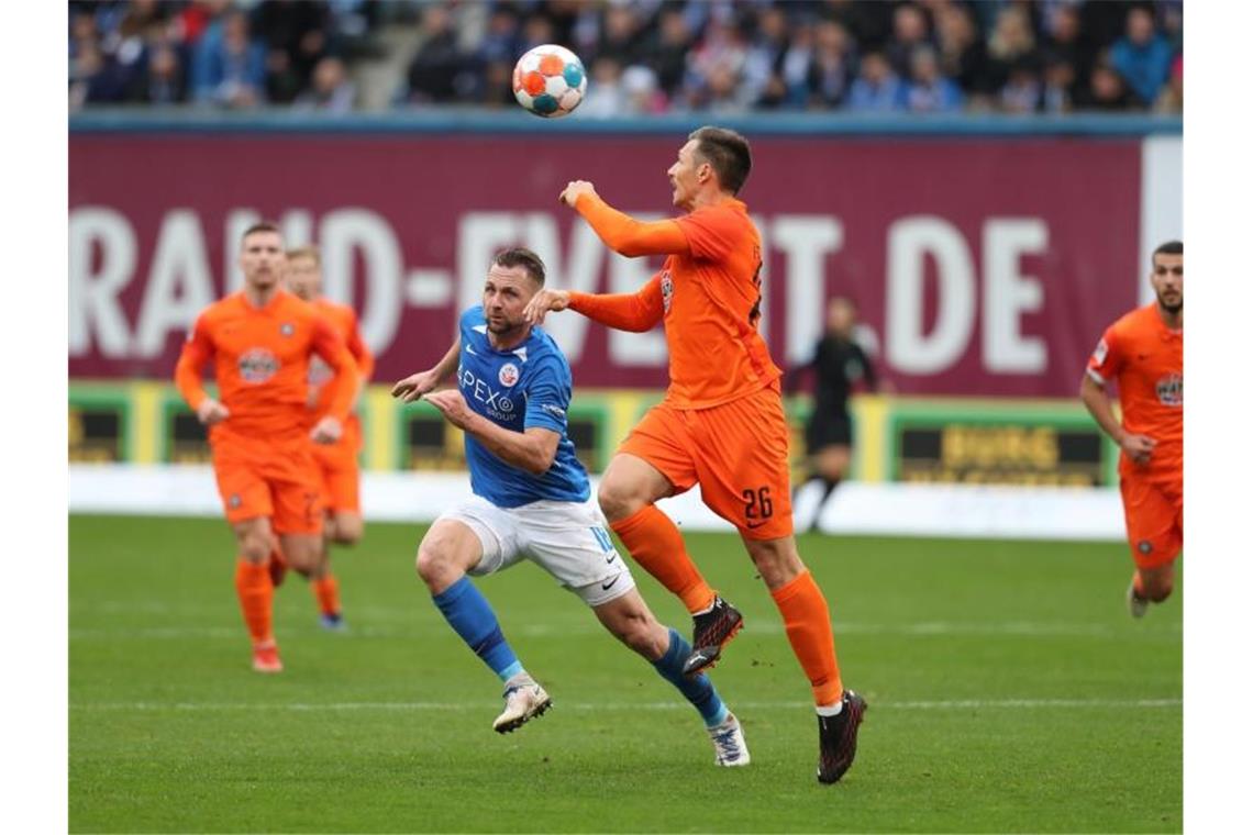 Darmstadt an Tabellenführung - Lieberknecht: „Wie im Rausch“ John Verhoek (l) von Hansa Rostock im Kampf um den Ball mit Sören Gonther (r) von Erzegebirge Aue. Foto: Danny Gohlke/dpa