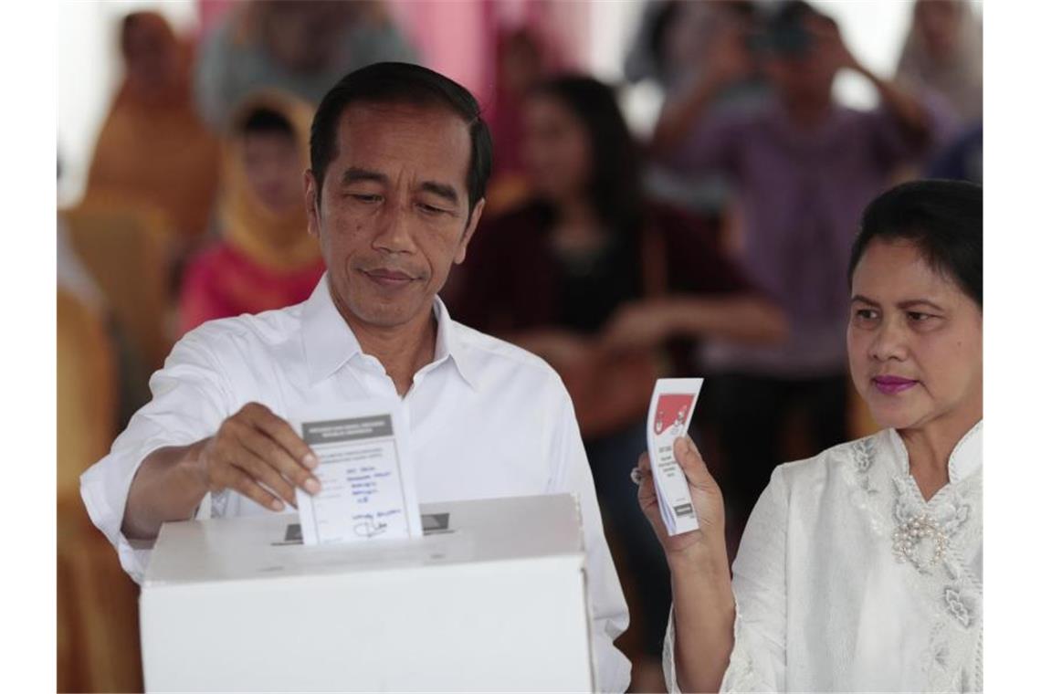 Joko Widodo und seine Frau Iriana geben am 17. April in einem Wahllokal ihre Stimme ab. Foto: Dita Alangkara/AP