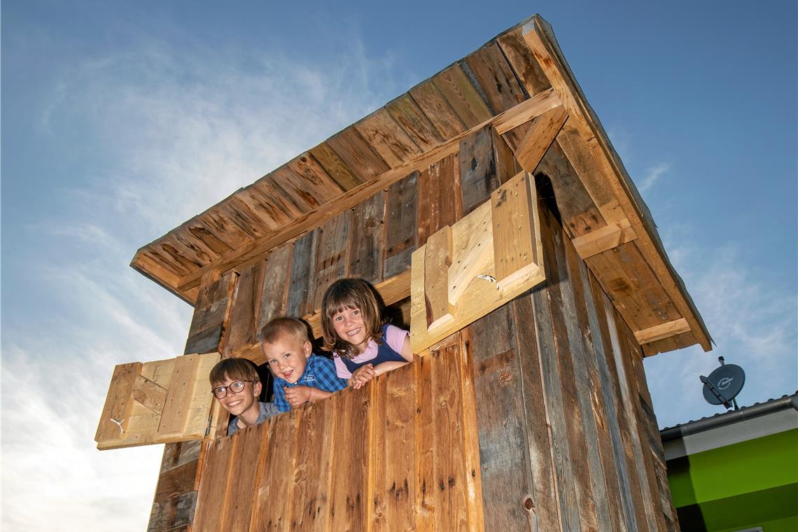 Spieldorado in luftigen Höhen Jonas, Janne und Emilia Mayer schauen aus dem Baumhaus. Foto: A. Becher