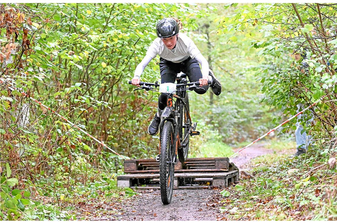 Jonathan Fettig (Nr. 1) springt über das Hindernis im Wald. 4. Kindercrossduathl...