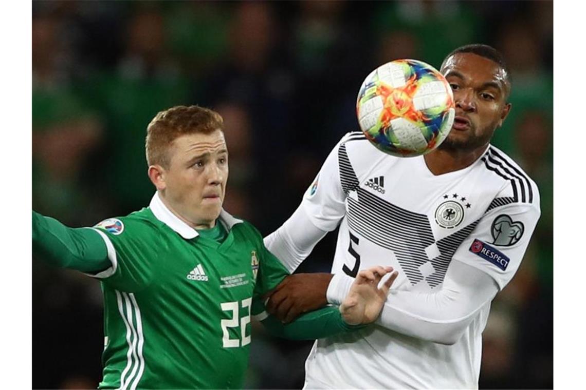 Jonathan Tah (r) im Duell um den Ball gegen Shayne Lavery (l) aus Nordirland. Foto: Christian Charisius