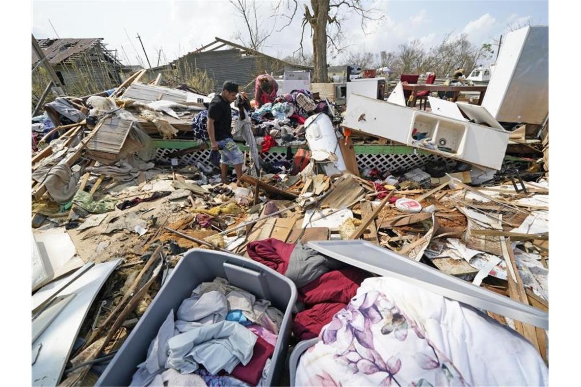 Biden besucht Katastrophengebiet - „Die Klimakrise ist da“ Jose Duran (l) hilft seiner Mutter Cruz Palma, die Überreste ihres Hauses nach dem Hurrikan Ida zu durchsuchen. Foto: David J. Phillip/AP/dpa