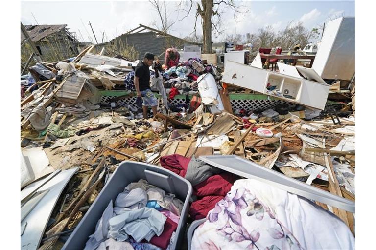 Jose Duran (l) hilft seiner Mutter Cruz Palma, die Überreste ihres Hauses nach dem Hurrikan Ida zu durchsuchen. Foto: David J. Phillip/AP/dpa