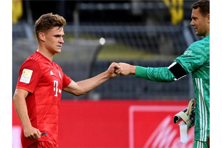 Joshua Kimmich (l) und Torwart Manuel Neuer grüßen sich mit der Faust. Foto: Federico Gambarini/dpa-Pool/dpa