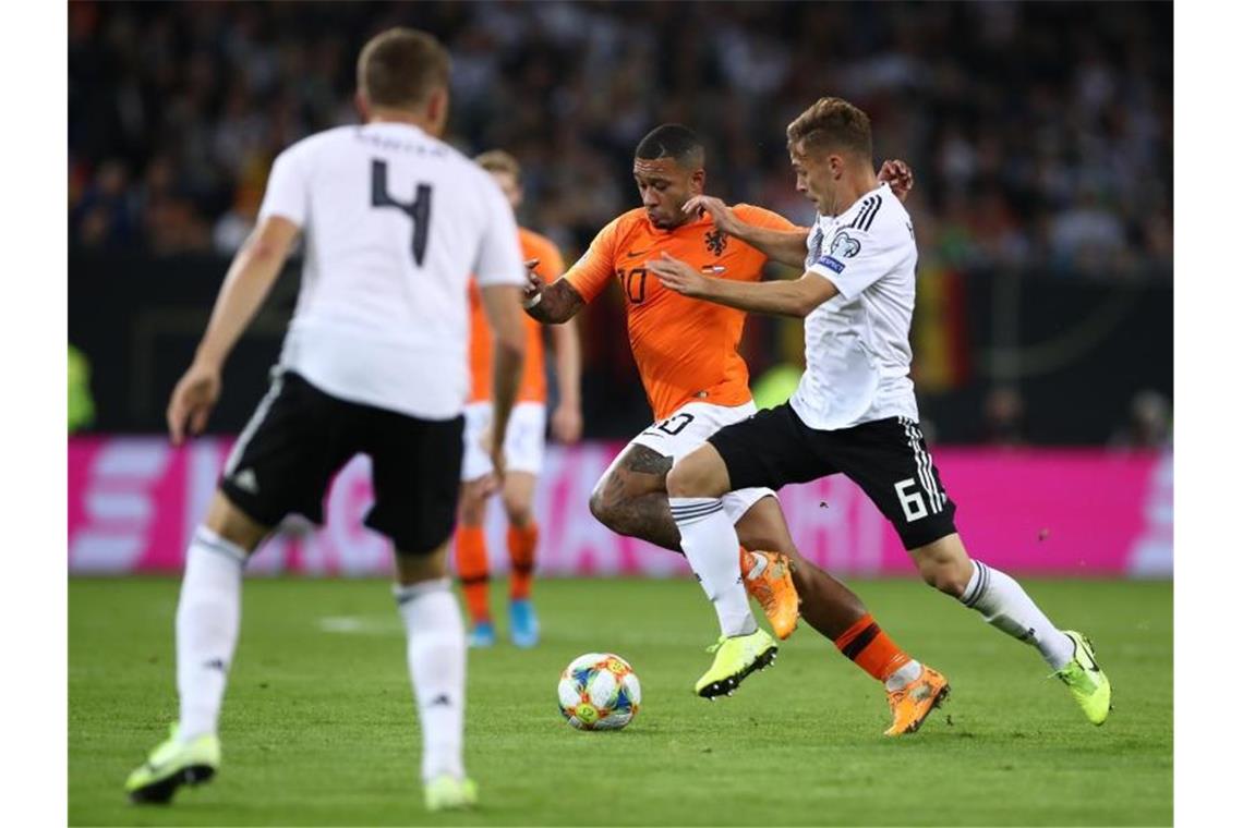 Joshua Kimmich (r) attackiert Memphis Depay. Foto: Christian Charisius