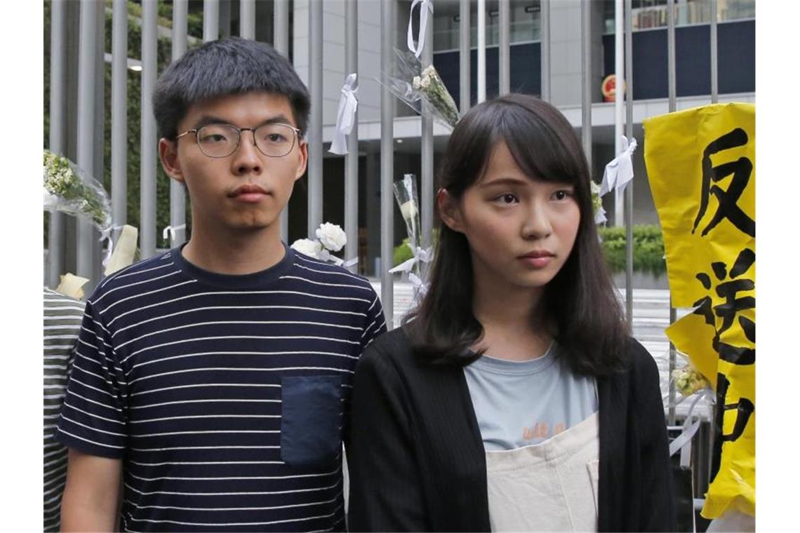 Joshua Wong (l) und Agnes Chow wird vorgeworfen, andere zur Teilnahme an einer illegalen Versammlung in Hongkong am 21. Juni animiert und selbst daran teilgenommen zu haben. Foto: Kin Cheung/AP