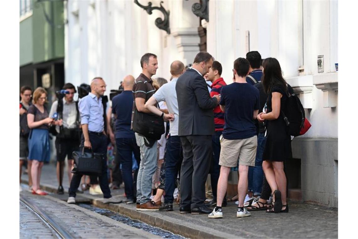 Freiburger Gruppenvergewaltigung: elf Angeklagte vor Gericht Journalisten und Prozessbeobachter stehen vor dem Prozessbeginn vor dem Landgericht. Foto: Patrick Seeger