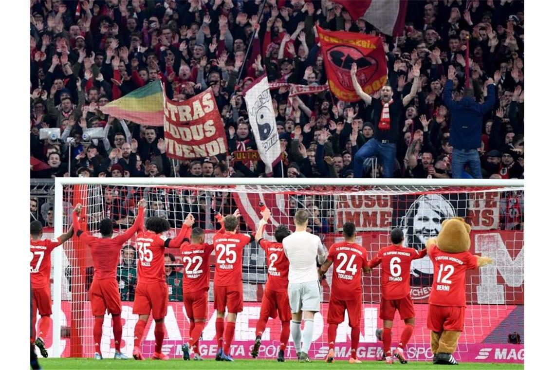Jubel bei Fans und Spielern: Der FC Bayern hat mit 3:2 gewonnen. Foto: Peter Kneffel/dpa