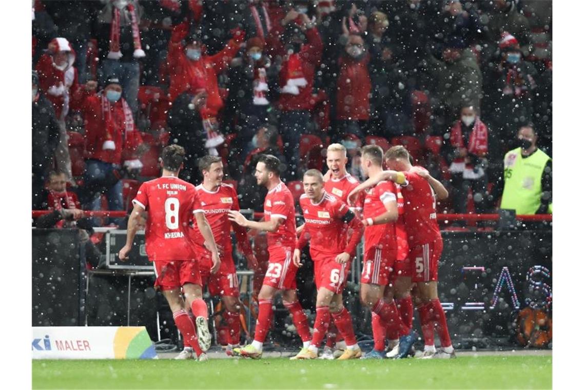 Jubel bei Schneefall im Stadion An der Alten Försterei: Die Spieler von Union Berlin feiern das 2:1 gegen RB Leipzig. Foto: Andreas Gora/dpa