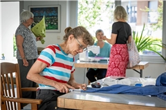 Judith Weis kürzt eine Hose und erhält dabei allerlei Tipps von anderen Bewohnerinnen. Foto: Alexander Becher