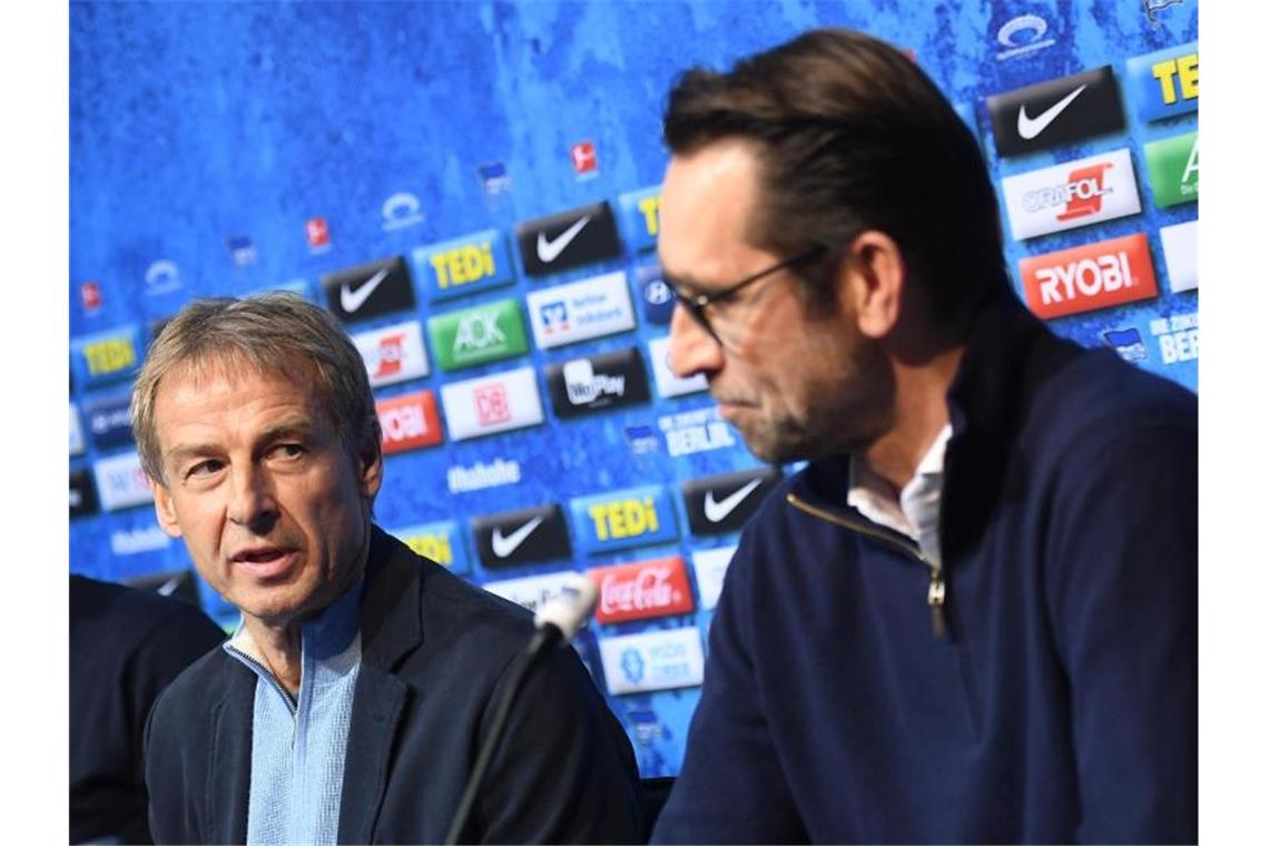 Jürgen Klinsmann (l) wird von Hertha-Manager Michael Preetz bei einer Pressekonferenz als Trainer präsentiert. Foto: Britta Pedersen/dpa