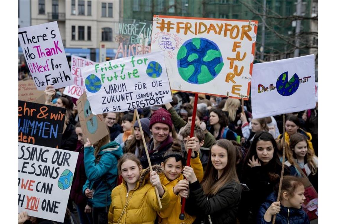 Jugendliche Teilnehmer der Klima-Kundgebung „Fridays for Future“ stehen mit Plakaten am Berliner Invalidenpark und fordern eine bessere Klimapolitk. Foto: Christoph Soeder