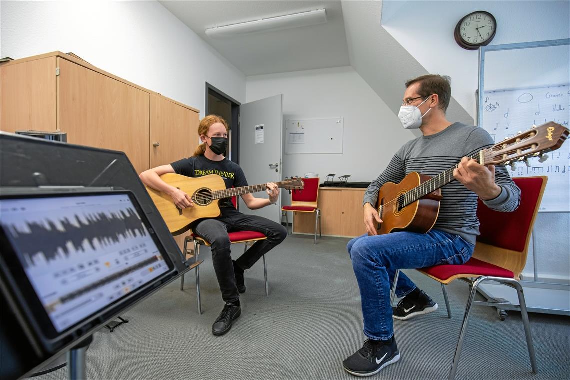 Jugendmusikschulgitarrenlehrer Burkhardt Wörnle und Schüler Joshua üben mit einer App. Foto: A. Becher