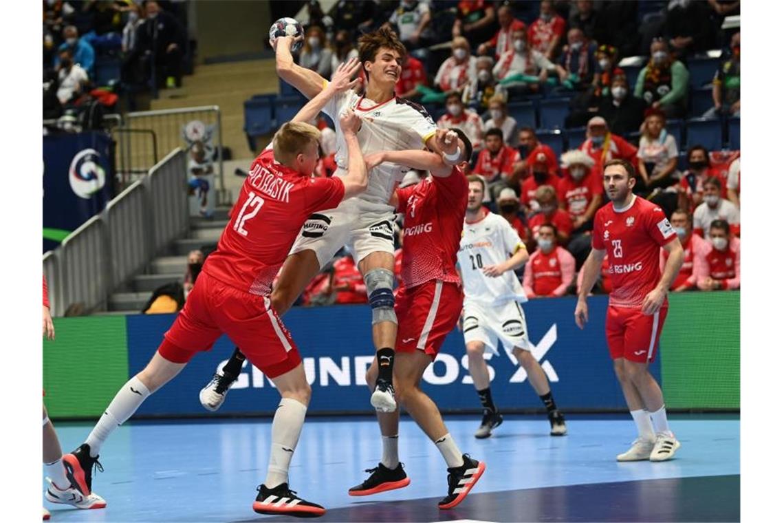 Dezimiertes DHB-Team trotzt Corona: Sieg gegen Polen Julian Köster (oben) setzt sich am Wurfkreis gegen die polnischen Abwehrversuche durch. Foto: Marijan Murat/dpa