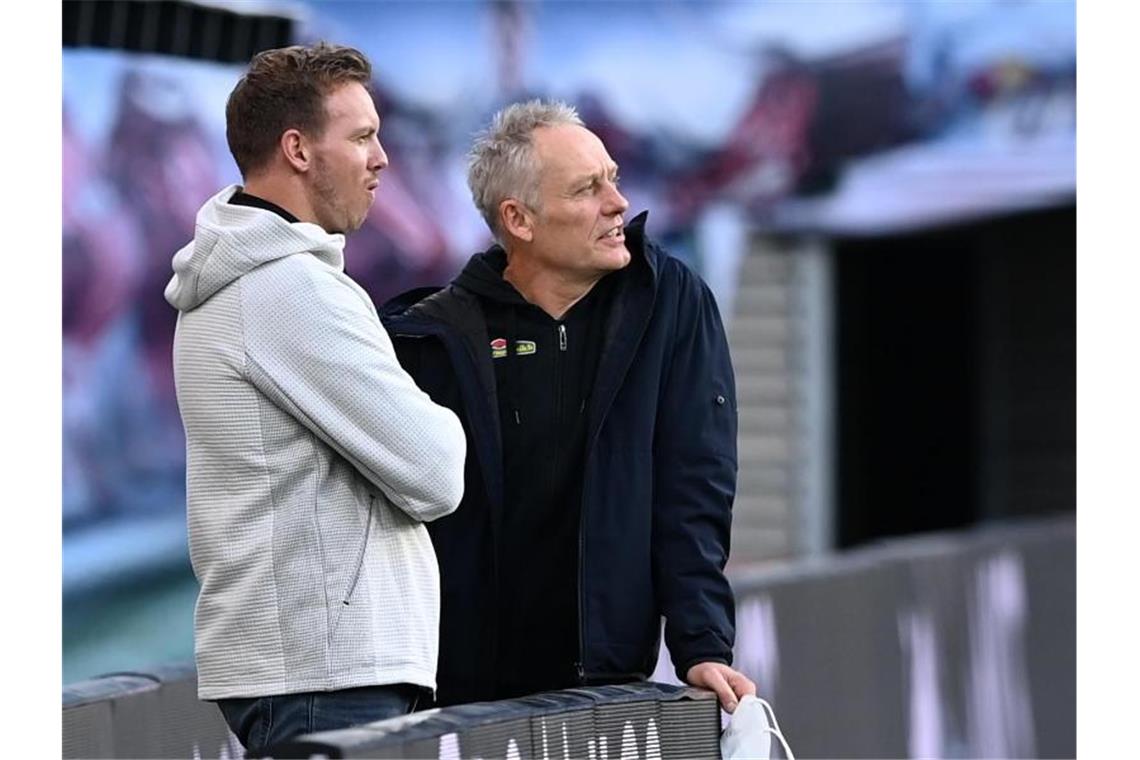 Streich adelt Nagelsmann: „Bei mir in dem Alter undenkbar“ Julian Nagelsmann (l) und Christian Streich unterhalten sich im Stadion. Foto: Hendrik Schmidt/dpa-Zentralbild/ZB/Archivbild