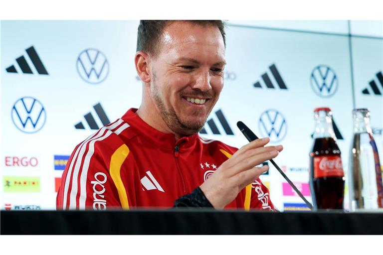 Julian Nagelsmann richtet das Mikrofon bei der Pressekonferenz.