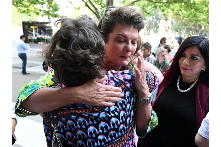 Julie Davis umarmt eine weitere Betroffene vor dem Gerichtsgebäude. Mehr als 1300 Frauen haben in Australien eine Sammelklage gegen den US-Pharmakonzern Johnson & Johnson wegen Gesundheitsstörungen infolge fehlerhafter Scheiden-Implantate gewonnen. Foto: Joel Carrett/AAP/dpa