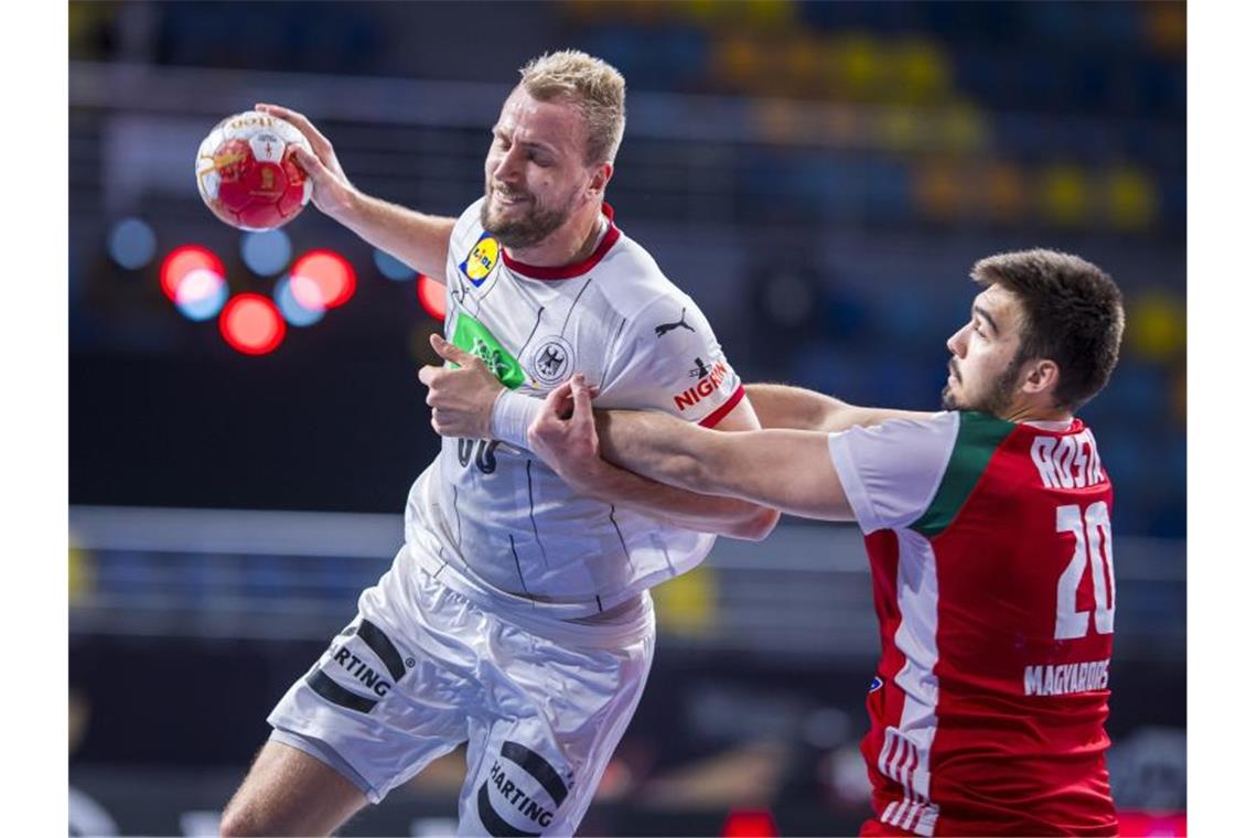 Deutsche Handballer müssen um WM-Viertelfinale bangen Julius Kühn (l) setzt sich am Wurfkreis gegen den Ungarn Miklos Rosta in Szene. Foto: Sascha Klahn/dpa