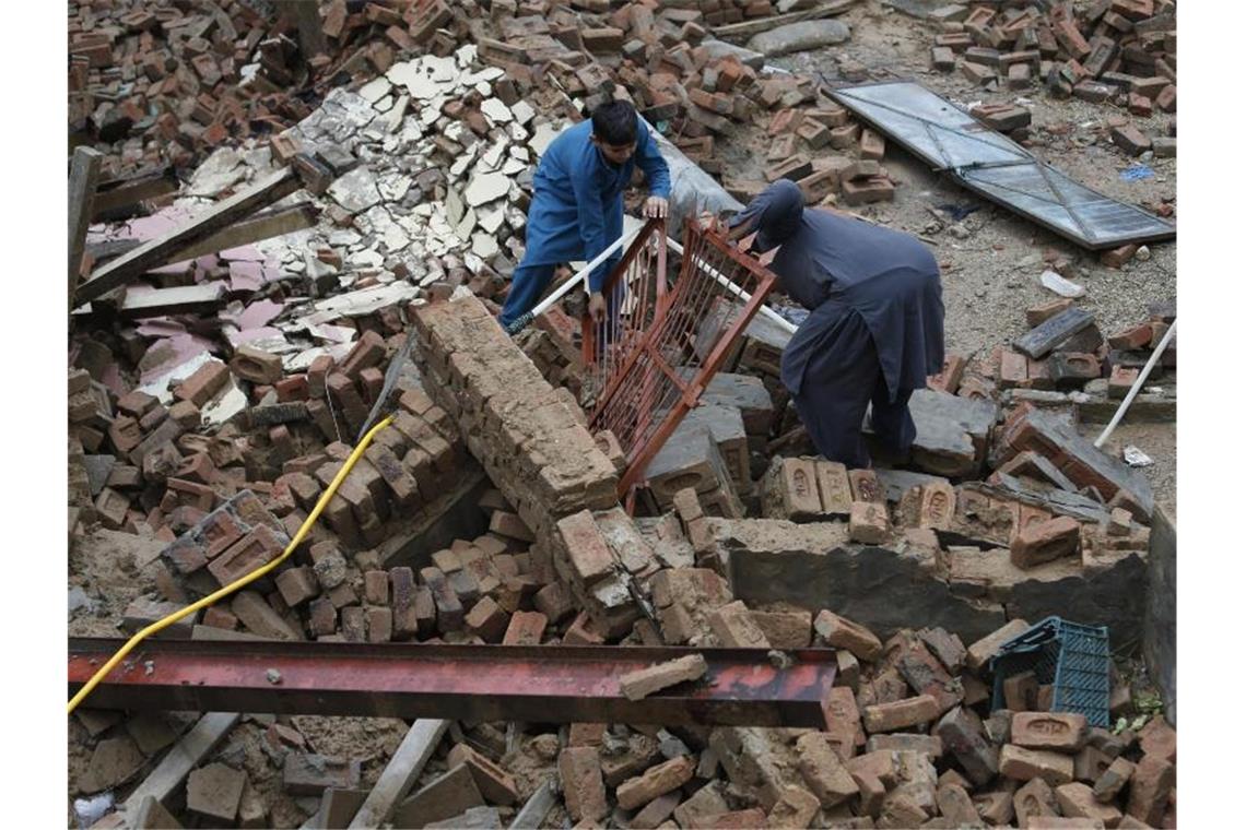 Jungen versuchen, Stücke aus dem Schutt eines Hauses zu bergen, das durch ein starkes Erdbeben im Nordosten Pakistans beschädigt wurde. Foto: Anjum Naveed/AP