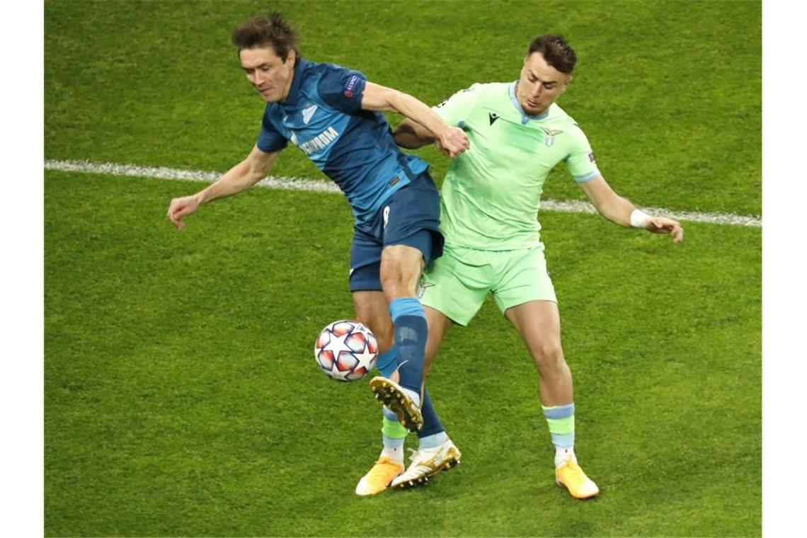 Juri Schirkow (l) von Zenit St. Petersburg und Patric von Lazio Rom kämpfen um den Ball. Foto: Mike Kireev/AP/dpa