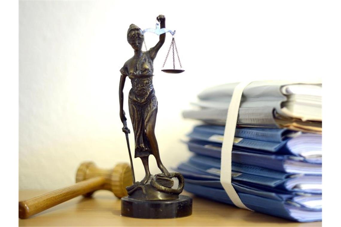 Justitia mit Holzhammer und Aktenstapel. Foto: Volker Hartmann/dpa/Symbolbild