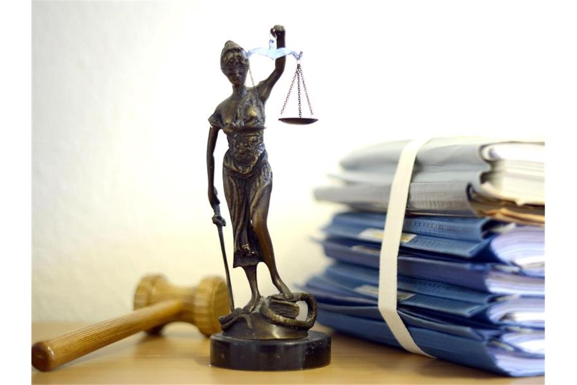 Justitia mit Holzhammer und Aktenstapel. Foto: Volker Hartmann/Archivbild