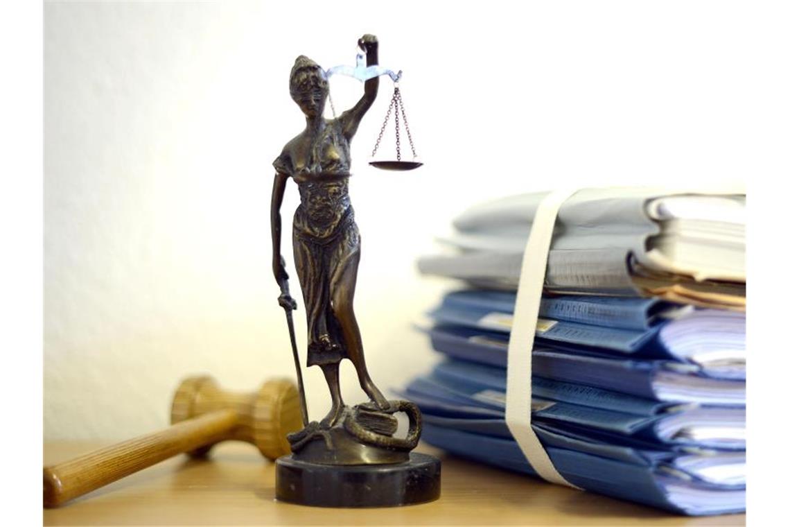 Justitia mit Holzhammer und Aktenstapel. Foto: Volker Hartmann/Archivbild