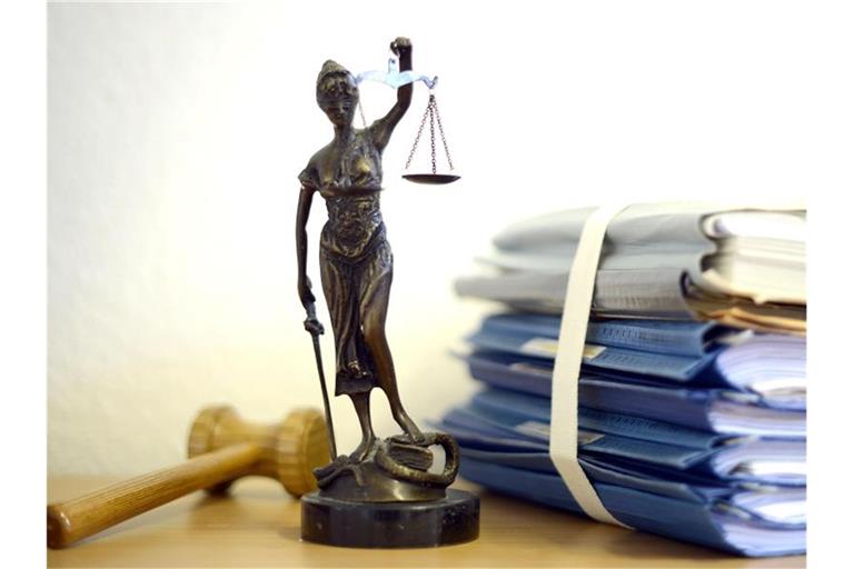 Justitia mit Holzhammer und Aktenstapel. Foto: Volker Hartmann/dpa/Symbolbild