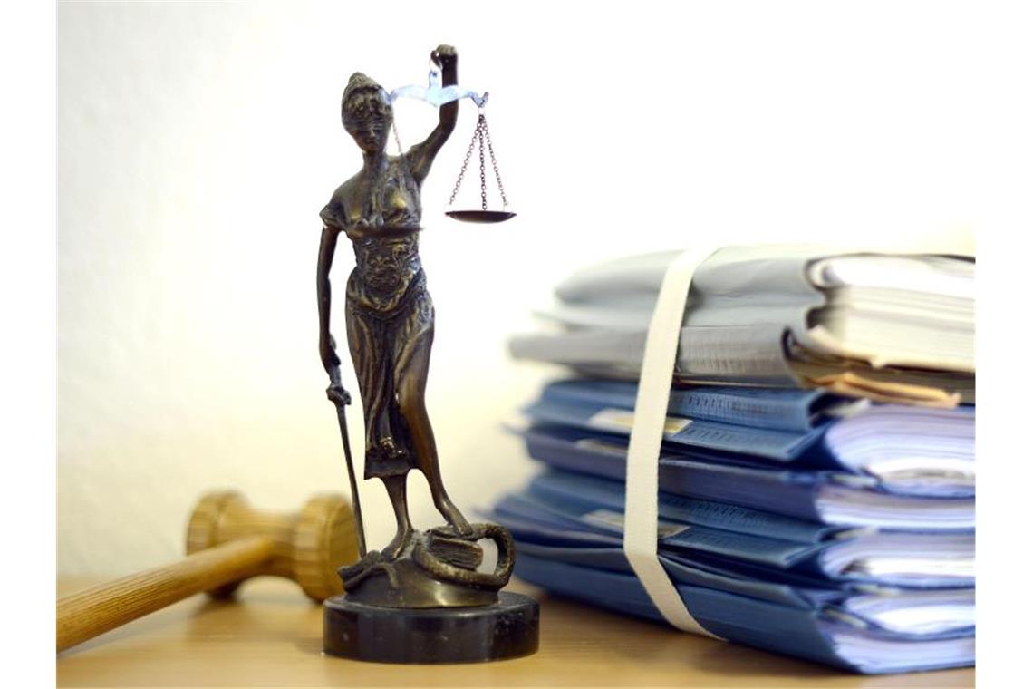 Justitia mit Holzhammer und Aktenstapel. Foto: Volker Hartmann/dpa/Symbolbild