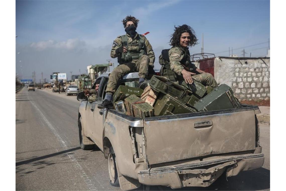 Kämpfer der Nationalen Befreiungsfront patrouillieren auf einer Straße. Foto: Anas Alkharboutli/dpa