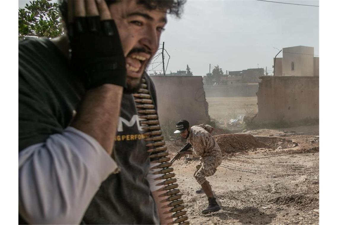 Kämpfer der Regierung gehen bei Zusammenstößen mit den Truppen der Libysch-Nationalen Armee in Deckung. Foto: Amru Salahuddien/XinHua/dpa