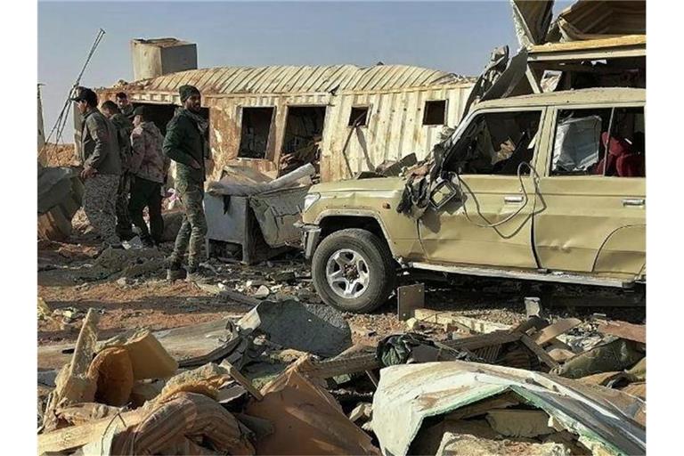 Kämpfer der schiitischen Miliz Kataib Hisbollah begehen ihr Hauptquartier, das durch einen US-Luftangriff zerstört wurde. Foto: -/AP/dpa