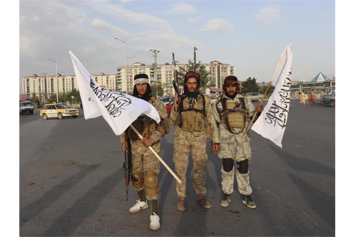 Was nach 20 Jahren Afghanistan-Einsatz bleibt Kämpfer der Taliban stehen mit Flaggen auf einer Straße in der afghanischen Hauptstadt Kabul. Foto: ---/AP/dpa