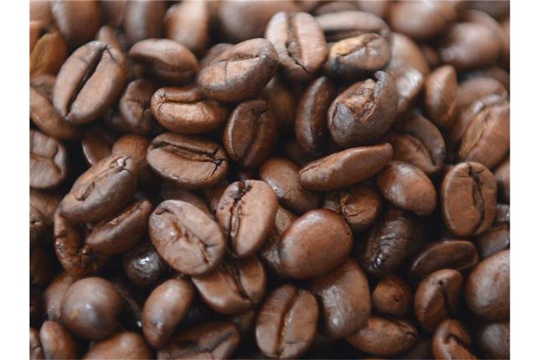 Kaffeebohnen liegen auf einem Tisch. Foto: Marcus Brandt/dpa/Symbolbild